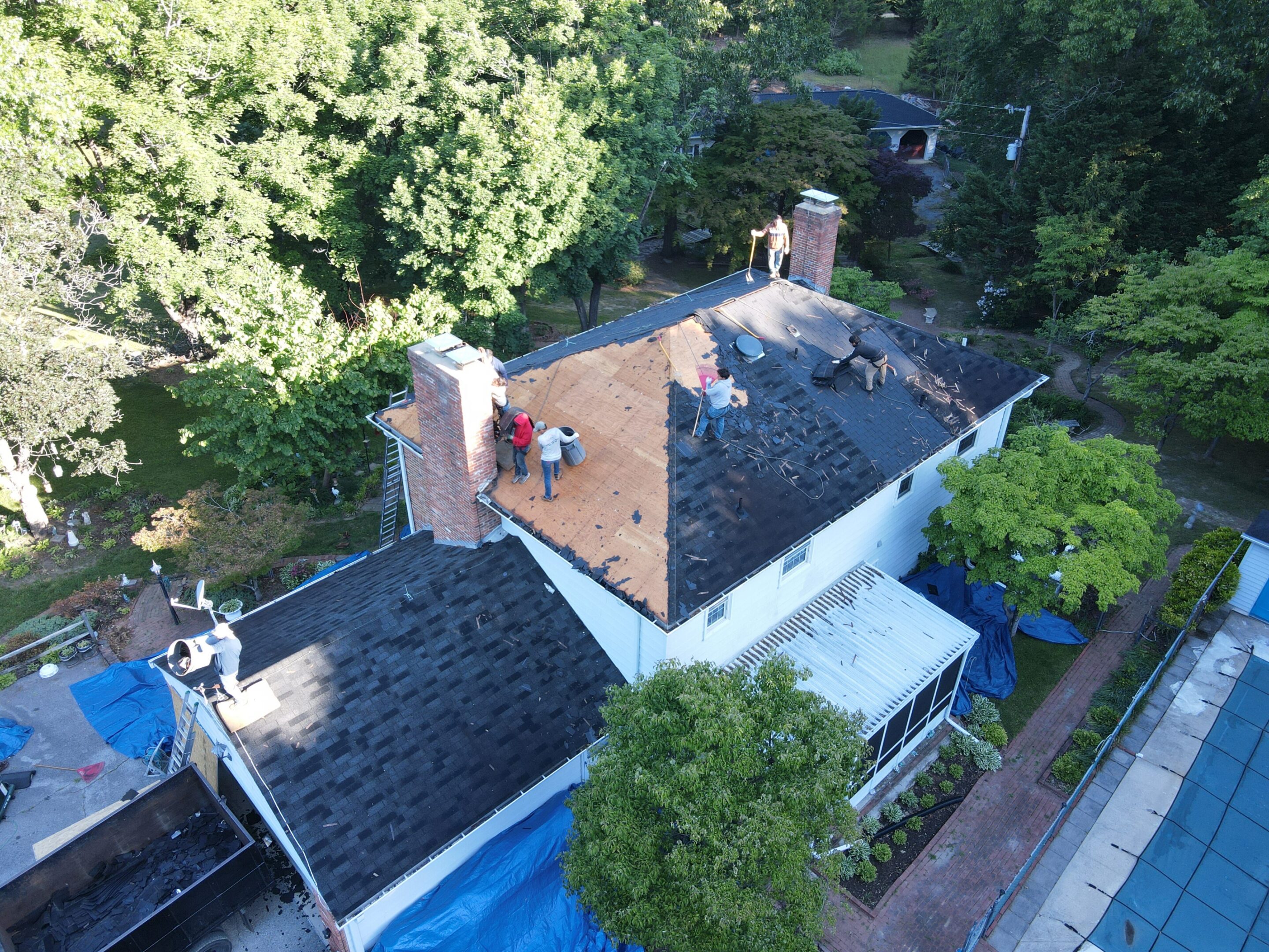 Roofers working on house roof renovation.